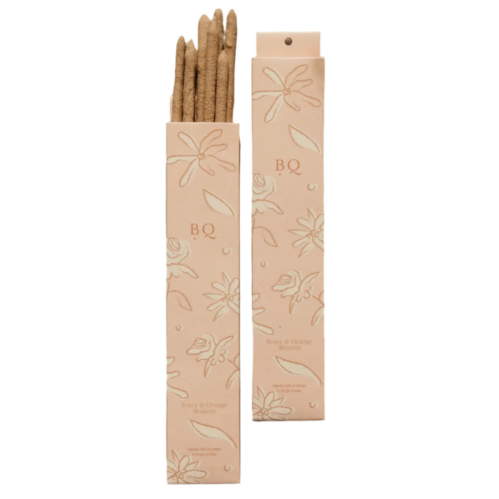 set of Blush pink boxes of BQ Botanical Thick Incense labeled "Roses & Orange Blossom," with floral illustrations and several thick incense sticks partially visible.