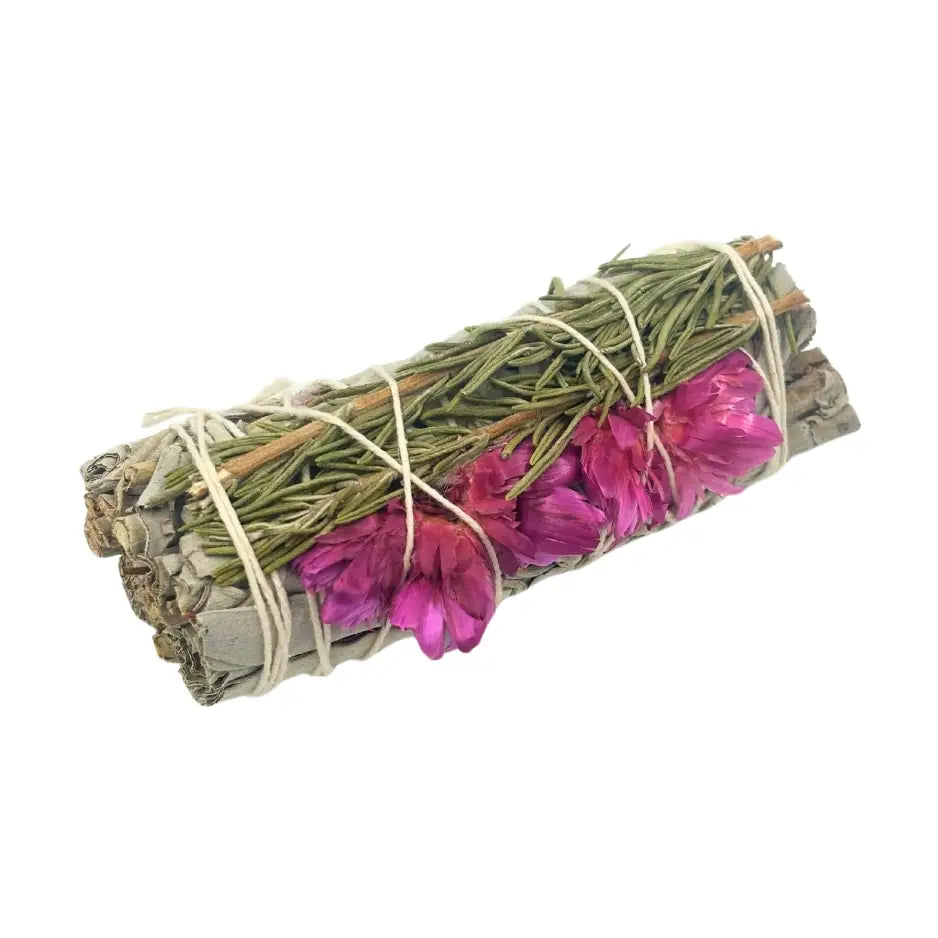 Smudge stick wrapped in sage and rosemary, decorated with bright pink sunflower petals, tied together with natural twine.