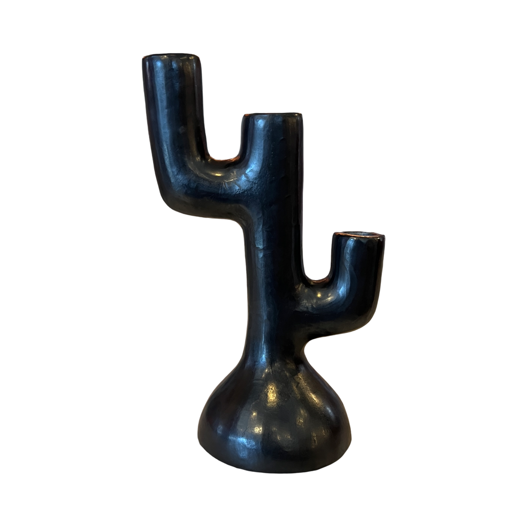 A matte black ceramic candle holder shaped like a saguaro cactus with three candle slots and a rounded base, handcrafted in a modern, sculptural design.