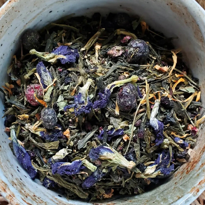 close up view of dried flowers and herbs in a ceramic bowl