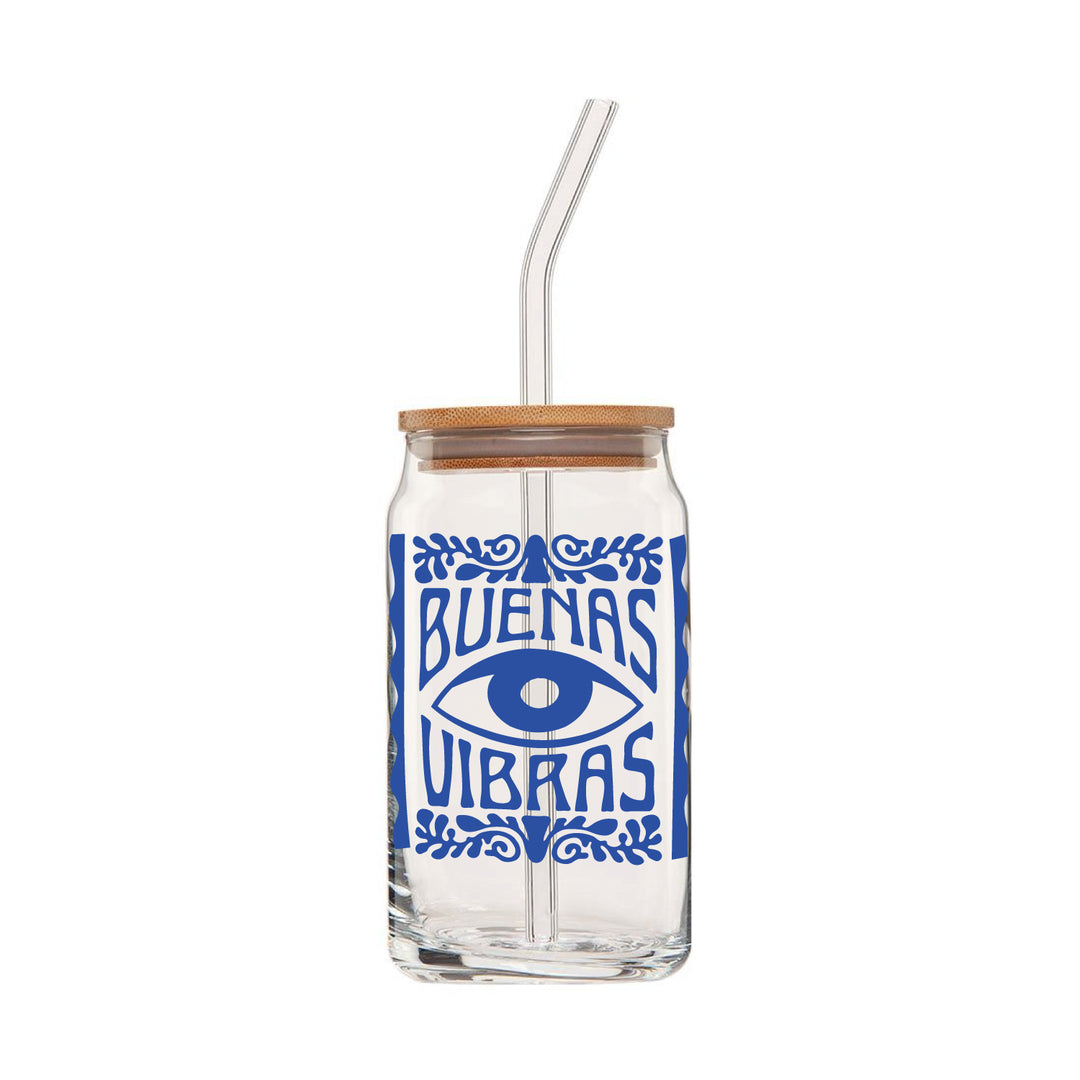 clear glass can with lid and glass straw that features a blue evil eye design design & text reading "Buenas Vibras"