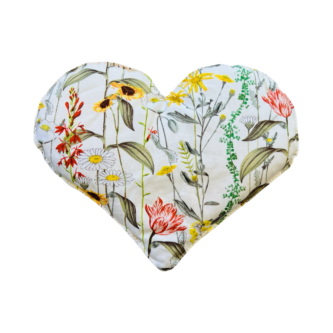 heart shaped eye pillow with a floral design on a white background