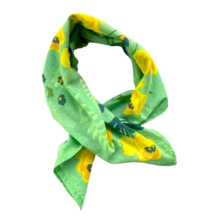 Green cotton handkerchief folded into a triangle and loosely knotted, featuring yellow daffodil flowers and leafy accents.