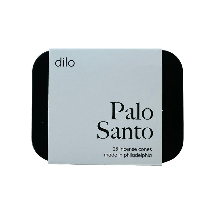 black rectangle tin with a white branded label with the phrase Palo Santo in black lettering.