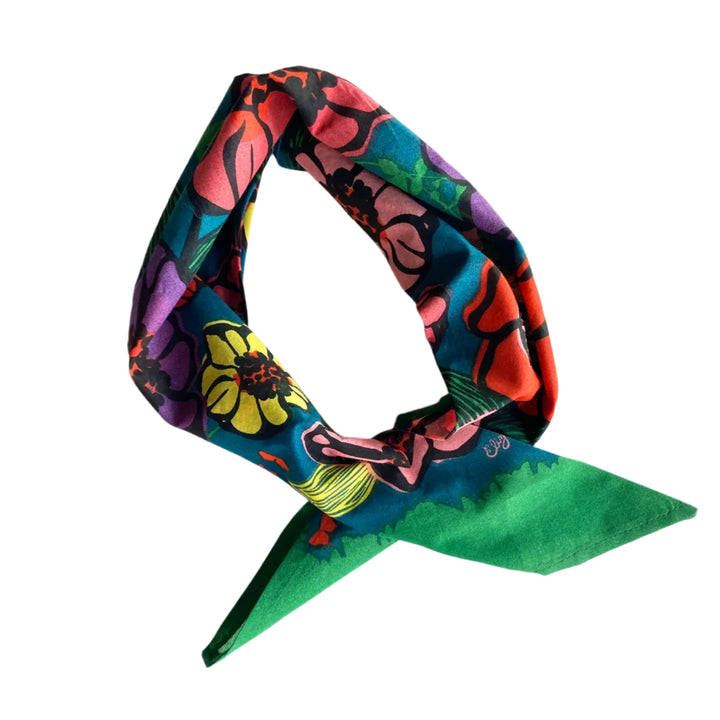 Colorful cotton handkerchief with a bold floral pattern in red, purple, yellow, and green tones, tied loosely in a triangle shape.
