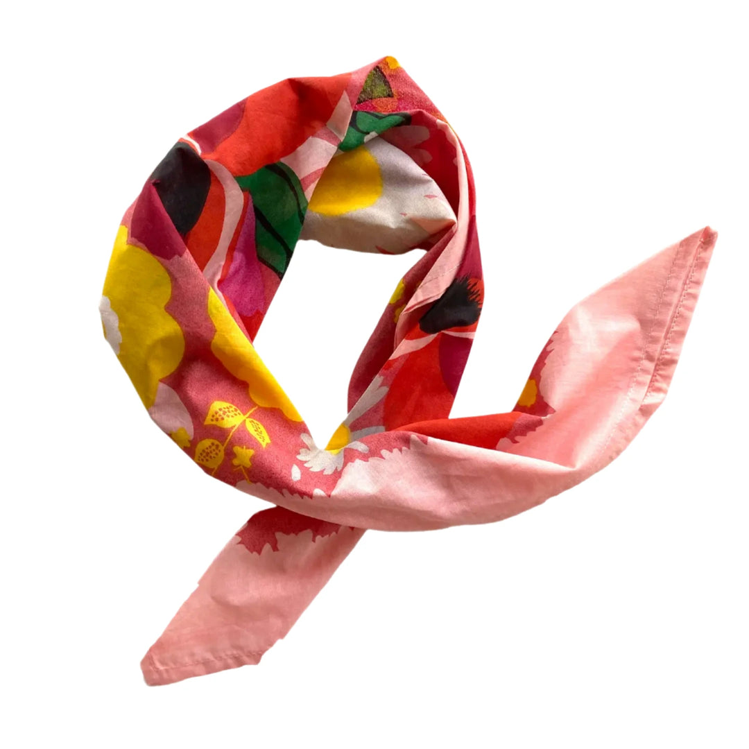 Cotton handkerchief with a vibrant floral print in pink, red, yellow, and green tones, styled in a loose knot.