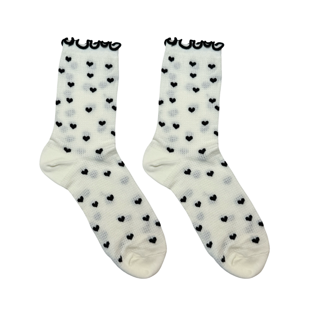 pair of cream socks with black hearts and a back ruffle trim on the cuff.