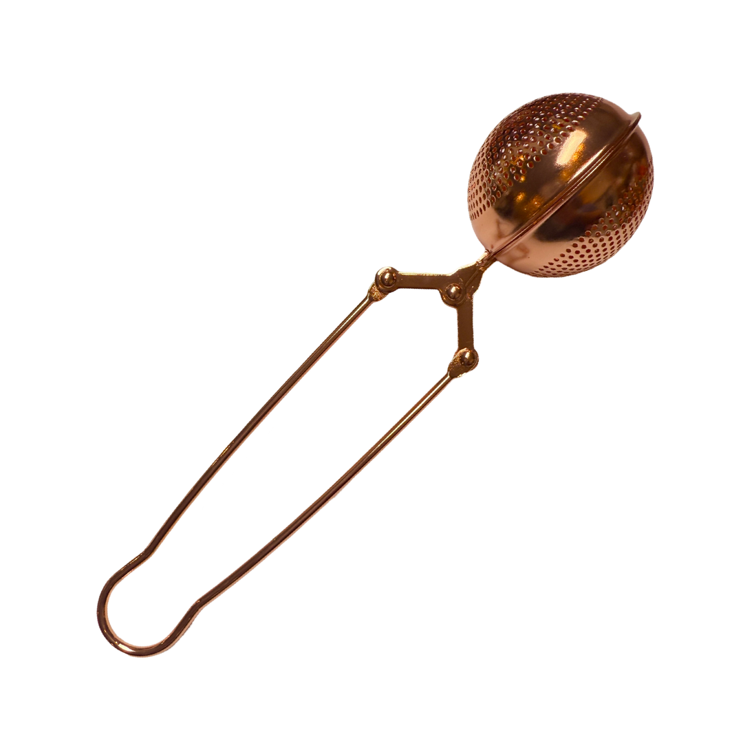 Side view of rose gold colored metal tea steeper