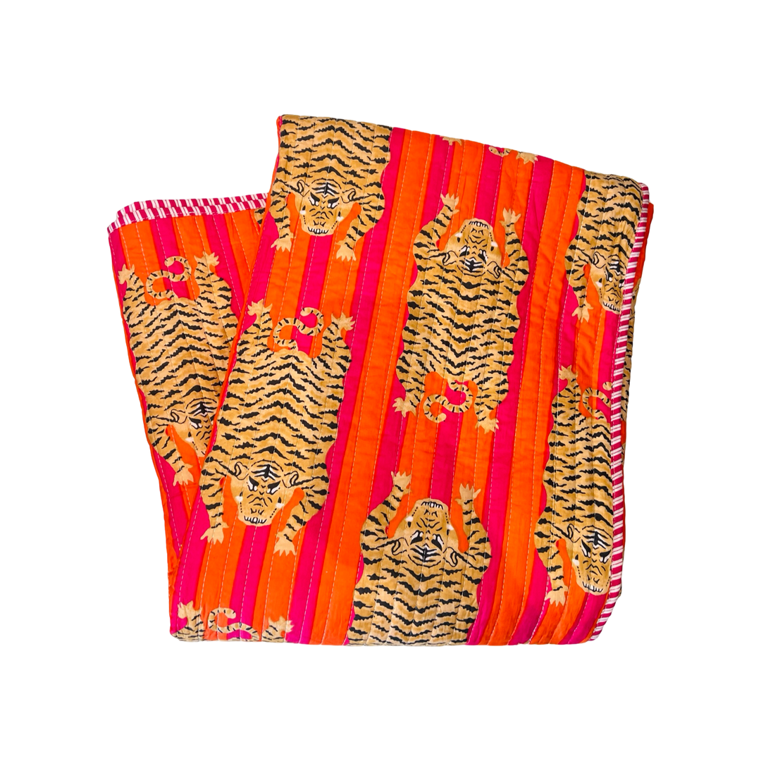 blanket folded in quarters with a orange and pink and tiger-striped pattern.