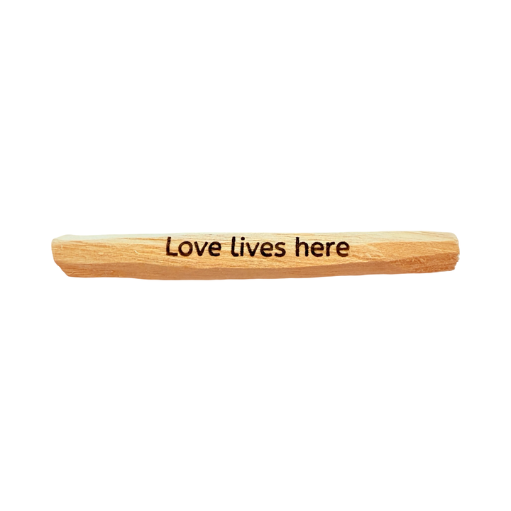 palo santo stick engraved with the phrase love lives here.