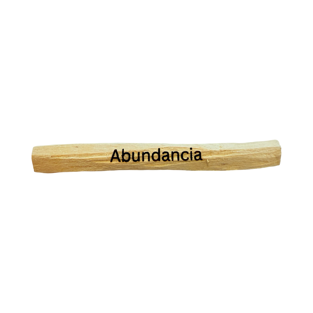 palo santo stick engraved with the word abundancia - abundance.