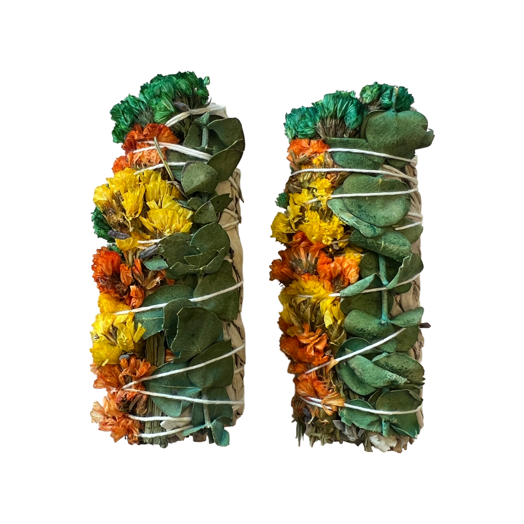 Two sage bundles with yellow and orange sinuata flowers and eucalyptus tied with white twine