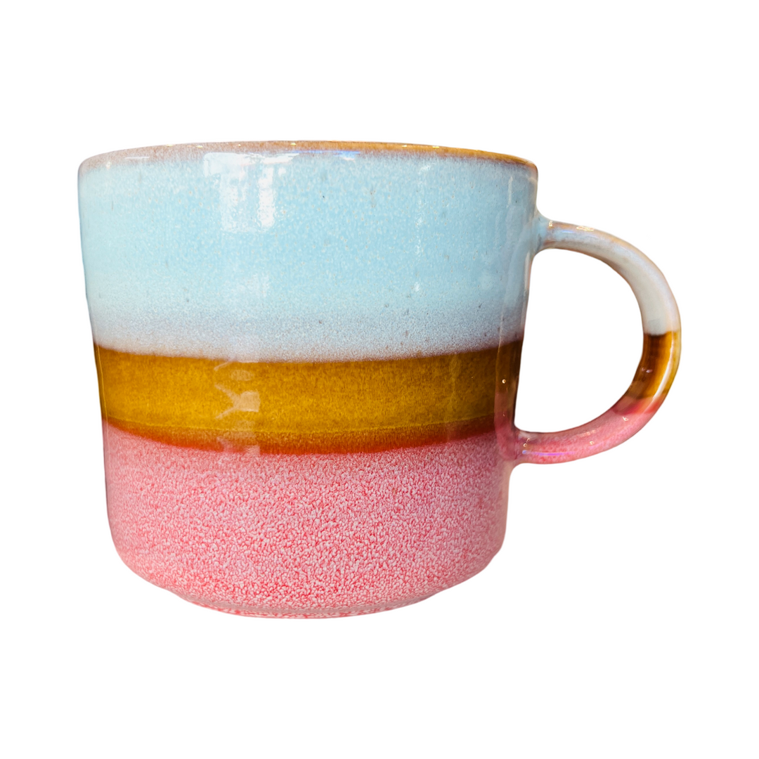 Stoneware mug featuring watery blues, sandy hues, and rosy pink colors.