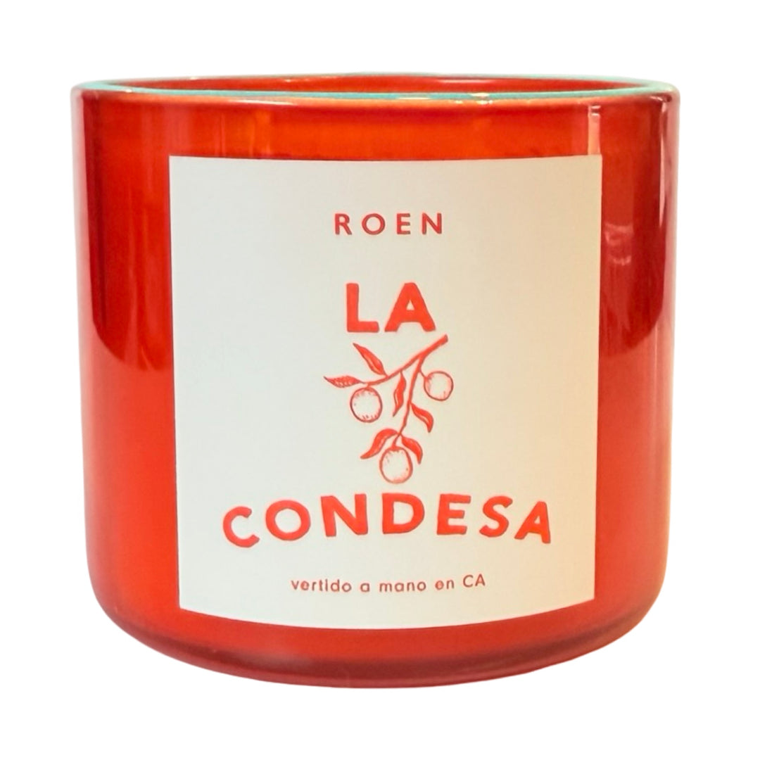 Photo of orange candle jar with branded label that reads "Roen - La Condesa - Vertido a mano en CA"