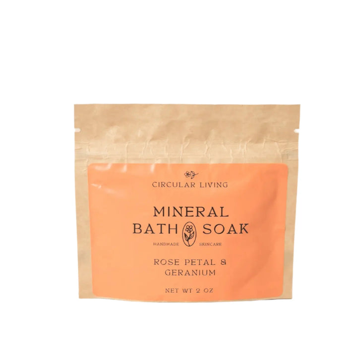 A kraft paper sachet labeled "Circular Living Mineral Bath Soak – Rose Petal & Geranium"