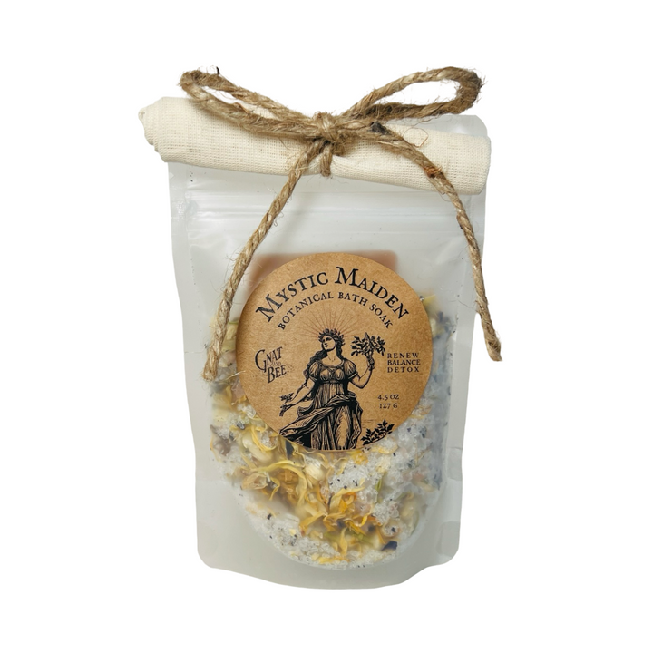 A frosted resealable pouch labeled "Mystic Maiden Botanical Bath Soak" with a twine bow and visible dried flowers inside.