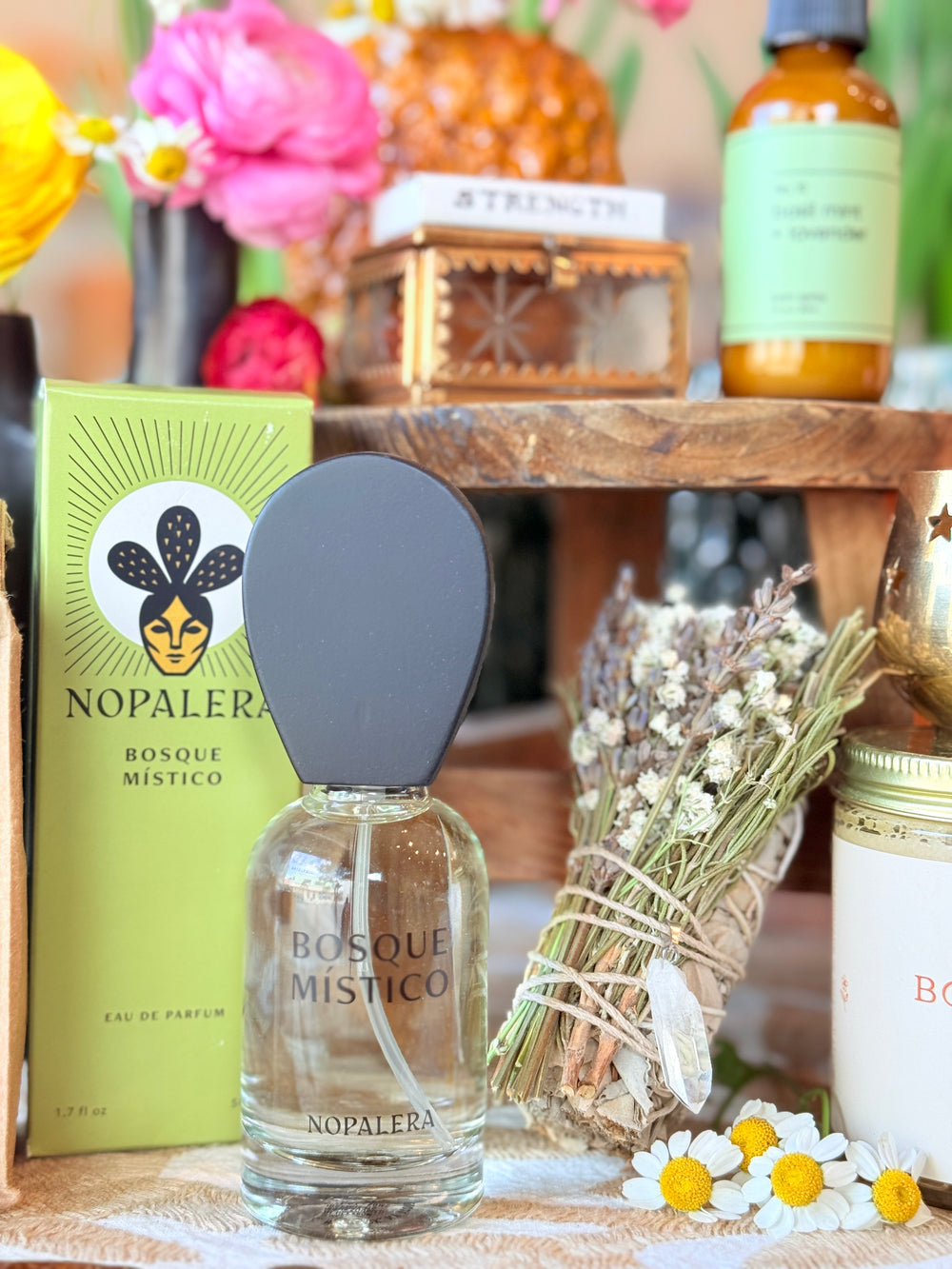 Photo of Nopalera Bosque Místico perfume alongside floral sage cleansing bundle with quartz pendant