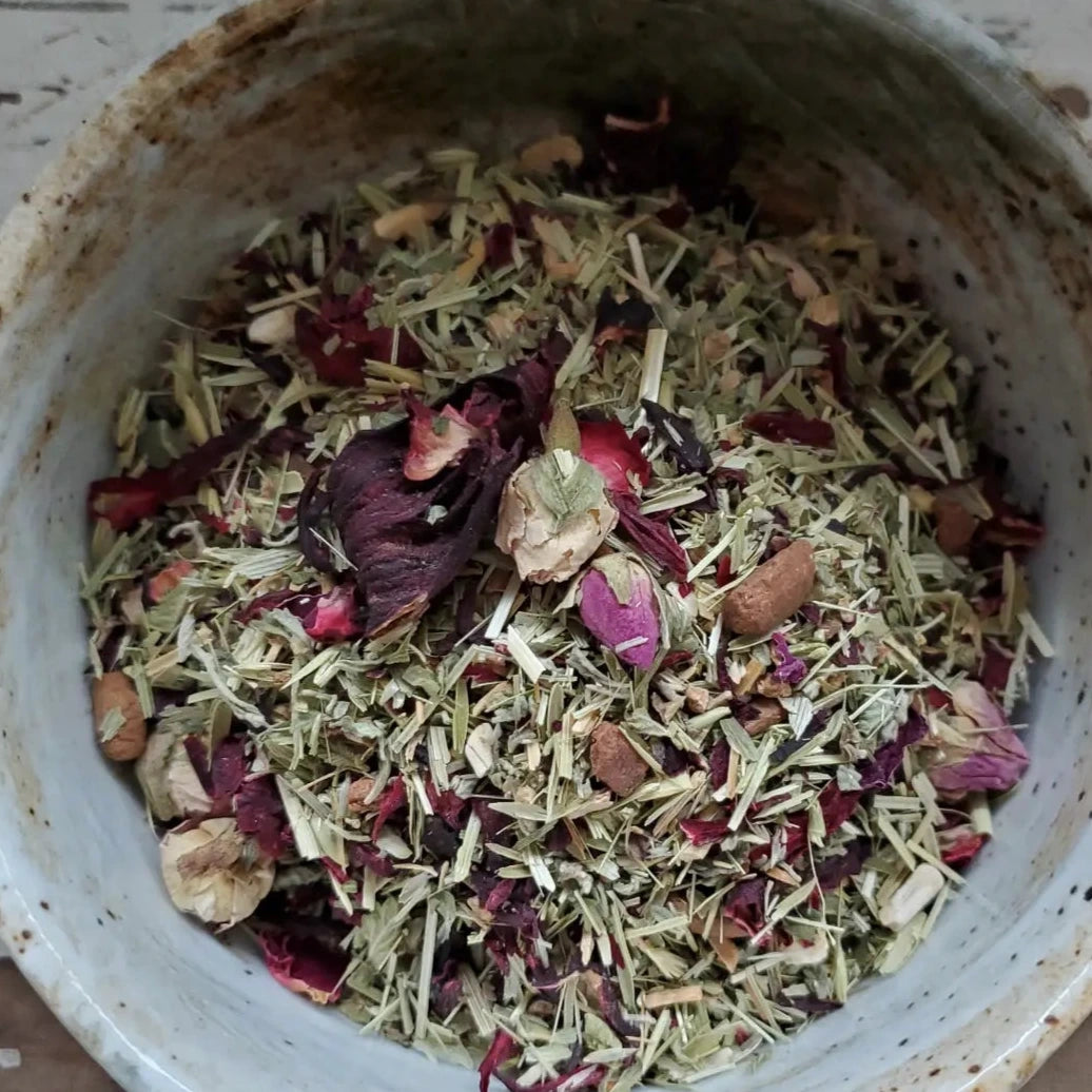 Close up view of dried herbs and flowers in a ceramic grey bowl