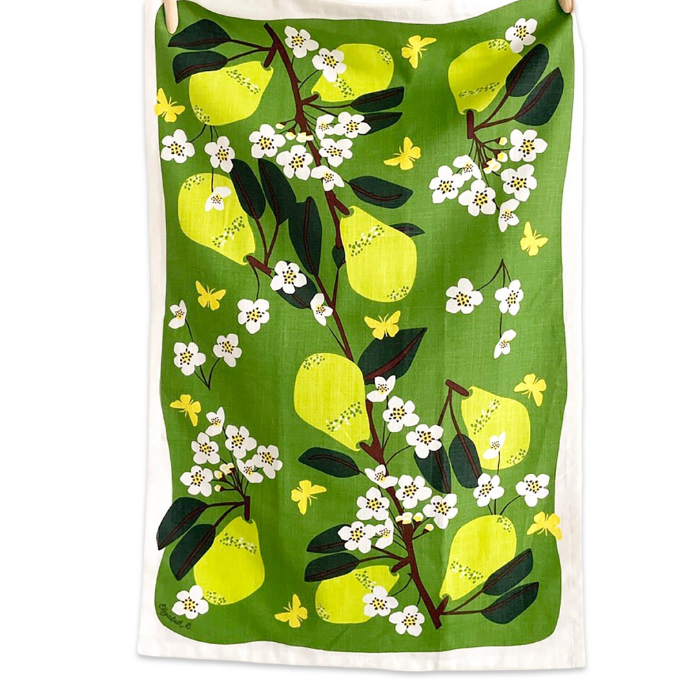 Green tea towel hanging on a string with a bright pear and blossom pattern in yellow, white, and green.