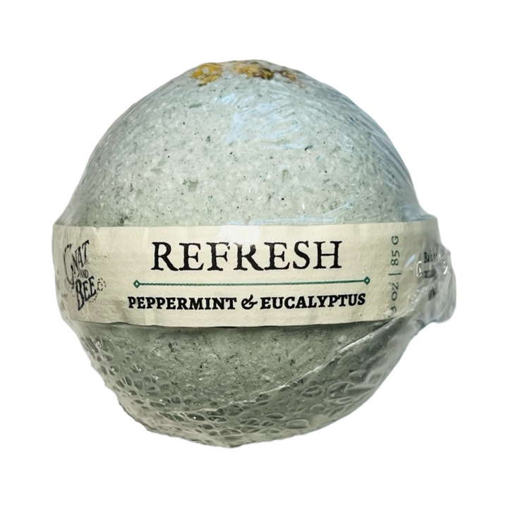 Wrapped bath bomb labeled "REFRESH – Peppermint & Eucalyptus" with dried chamomile flowers on top.