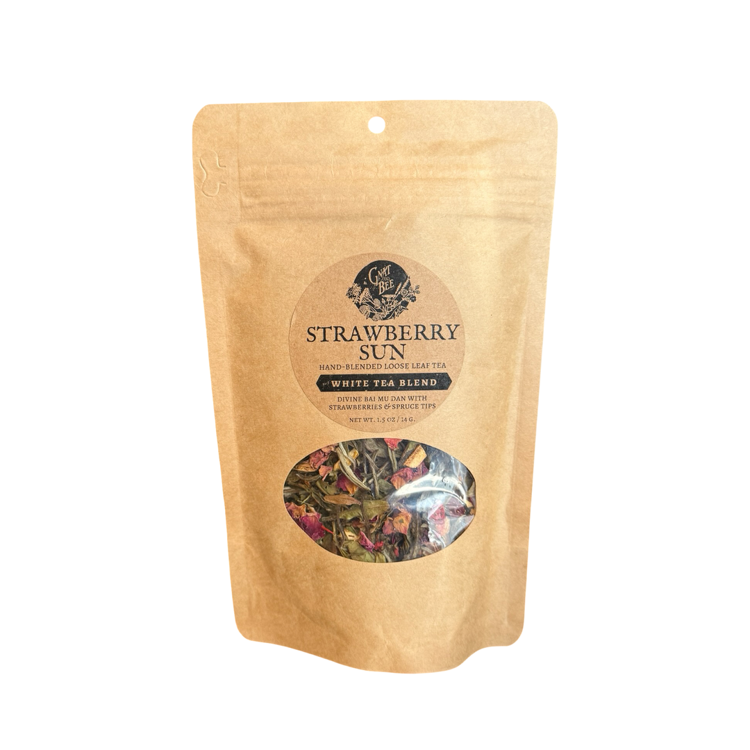 2 oz kraft paper package of Strawberry Sun White Tea with visible loose tea inside with colorful dried ingredients.