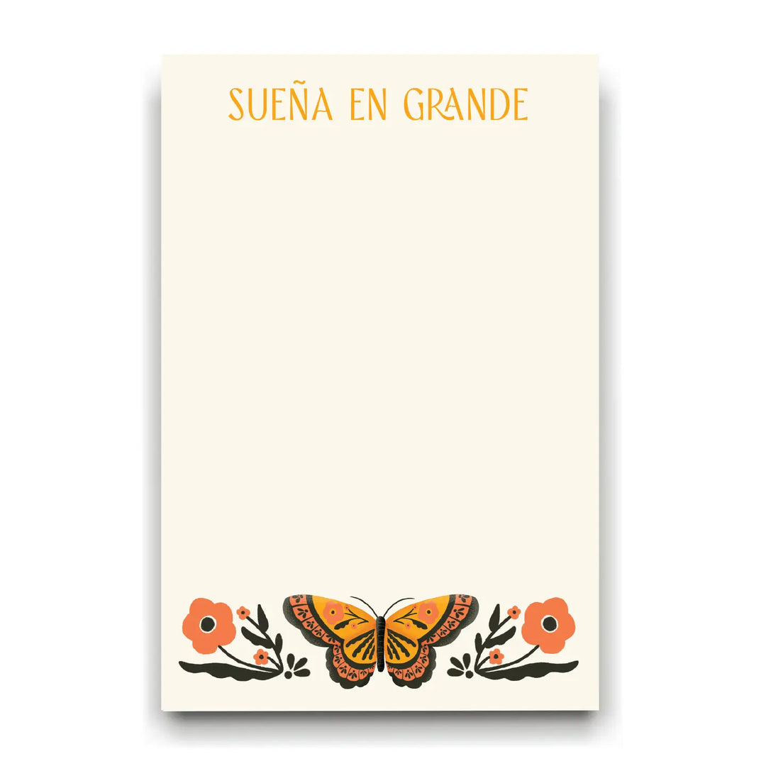 cream notepad that features an orange and black butterfly with orange flowers. features the saying Sueña En Grande (dream big) in orange lettering.