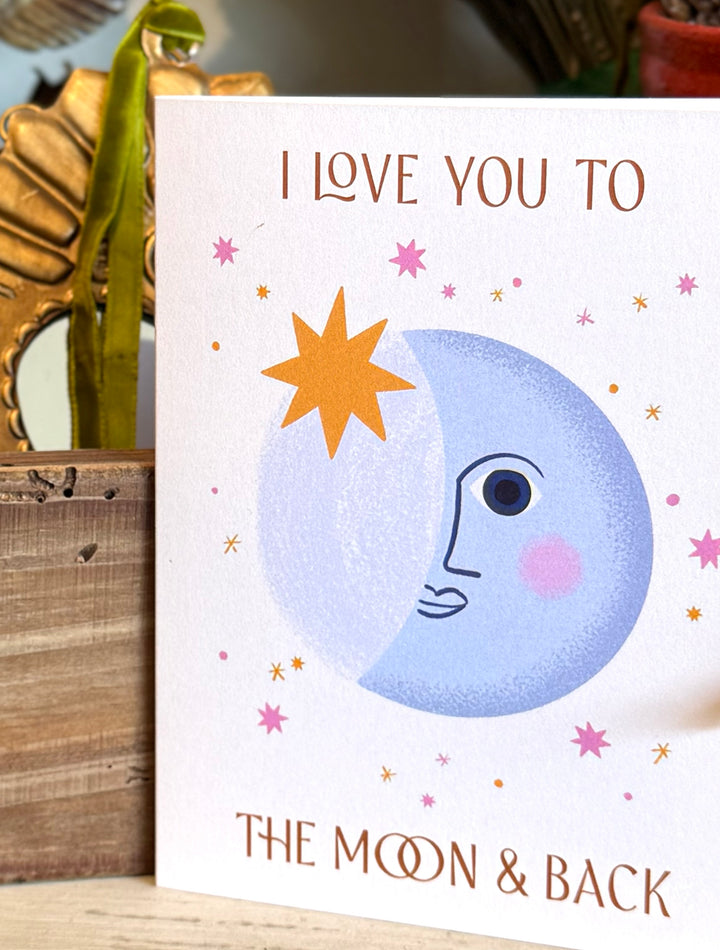 greeting card that reads "I love you to the moon & back" with a whimsical moon design