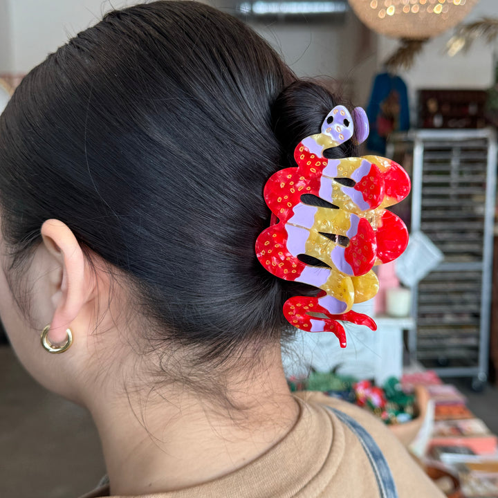 orange, pink and red patterns with golden accents hand painted snake hair claw clip.