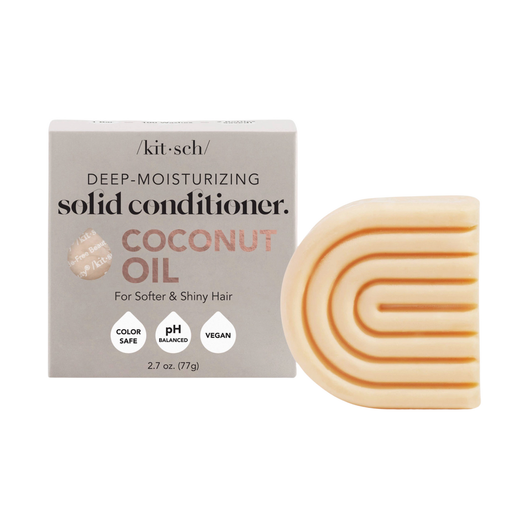 Light gray branded box of conditioner bar and at its side a peach colored bar of conditioner in the shape of a rainbow. Brand: Kitsch