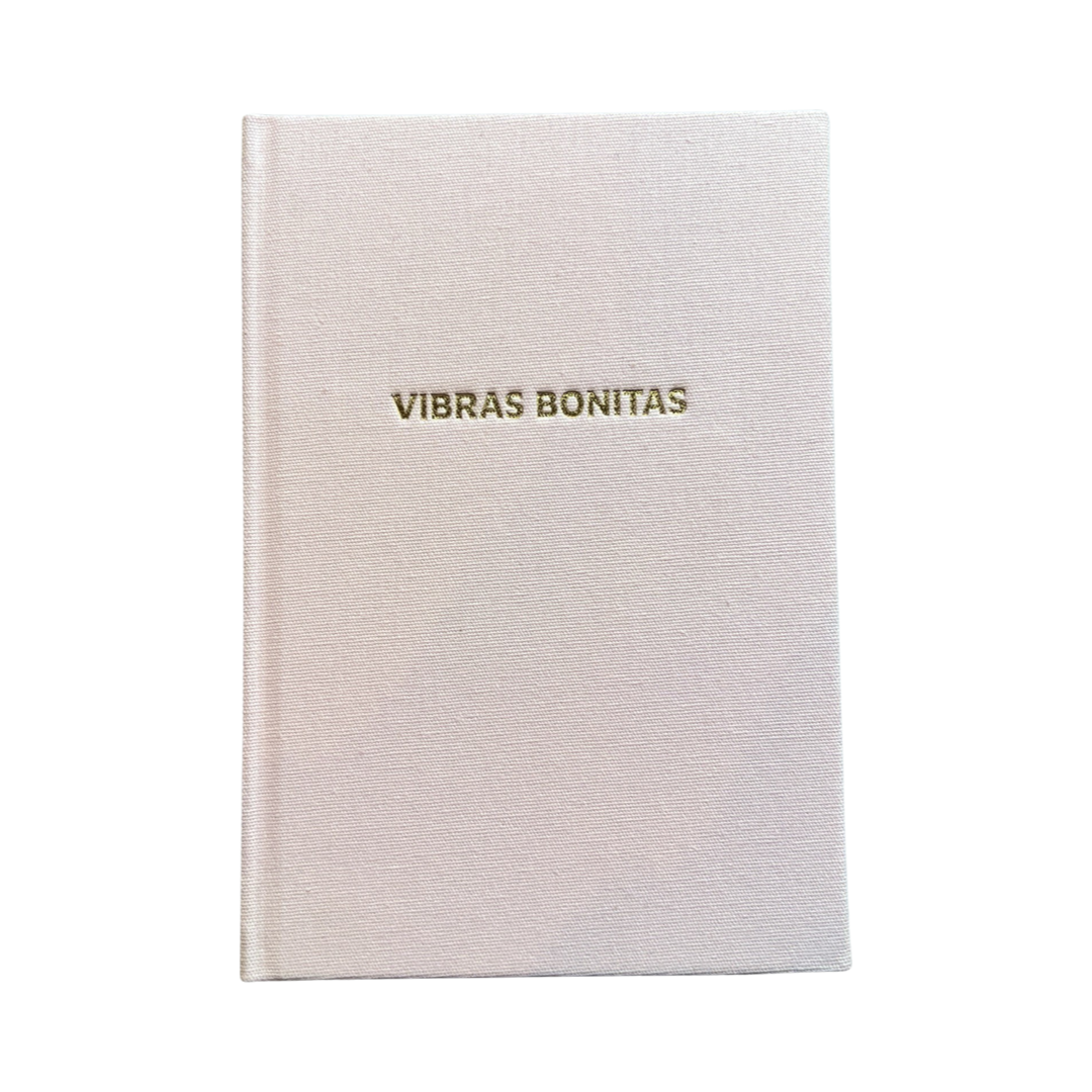Blush colored hardcover journal with the phrase VIbras Bonitas in gold foil lettering