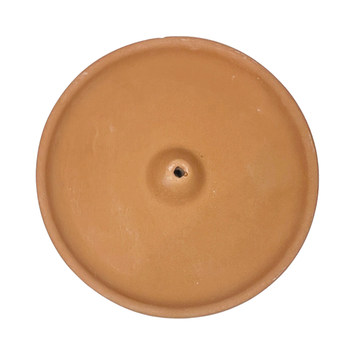 top view of a round terracotta colored incense holder