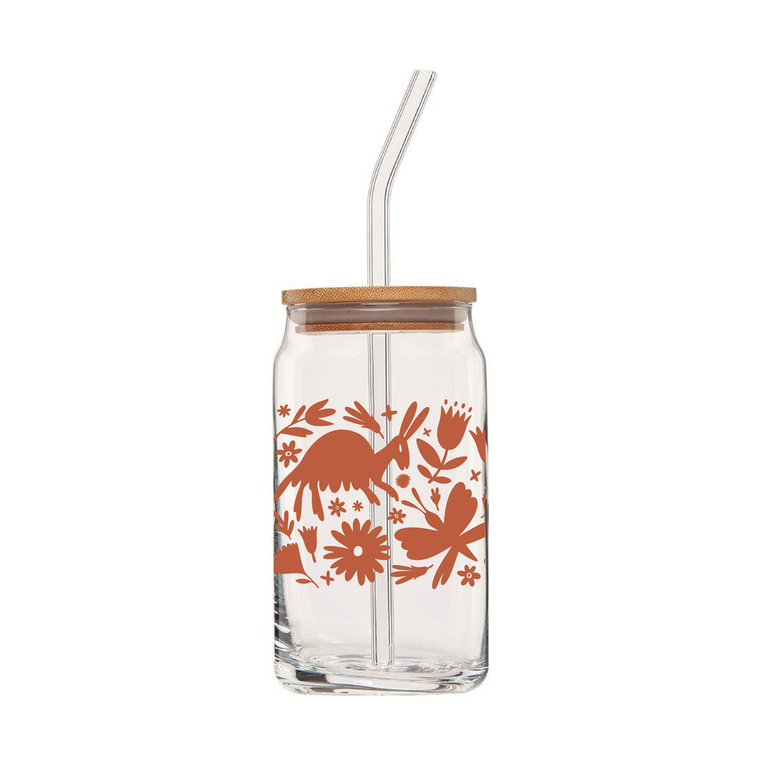 Front view of clear can glass featuring a wraparound print of a terra cotta colored otomi design. This glass also comes with a bamboo lid & a clear glass drinking straw.