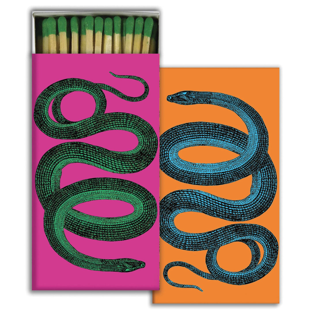 set of matches with two colors,orange and pink, and with an image of a snake on each side, one green and one blue. One box is open with exposed matches