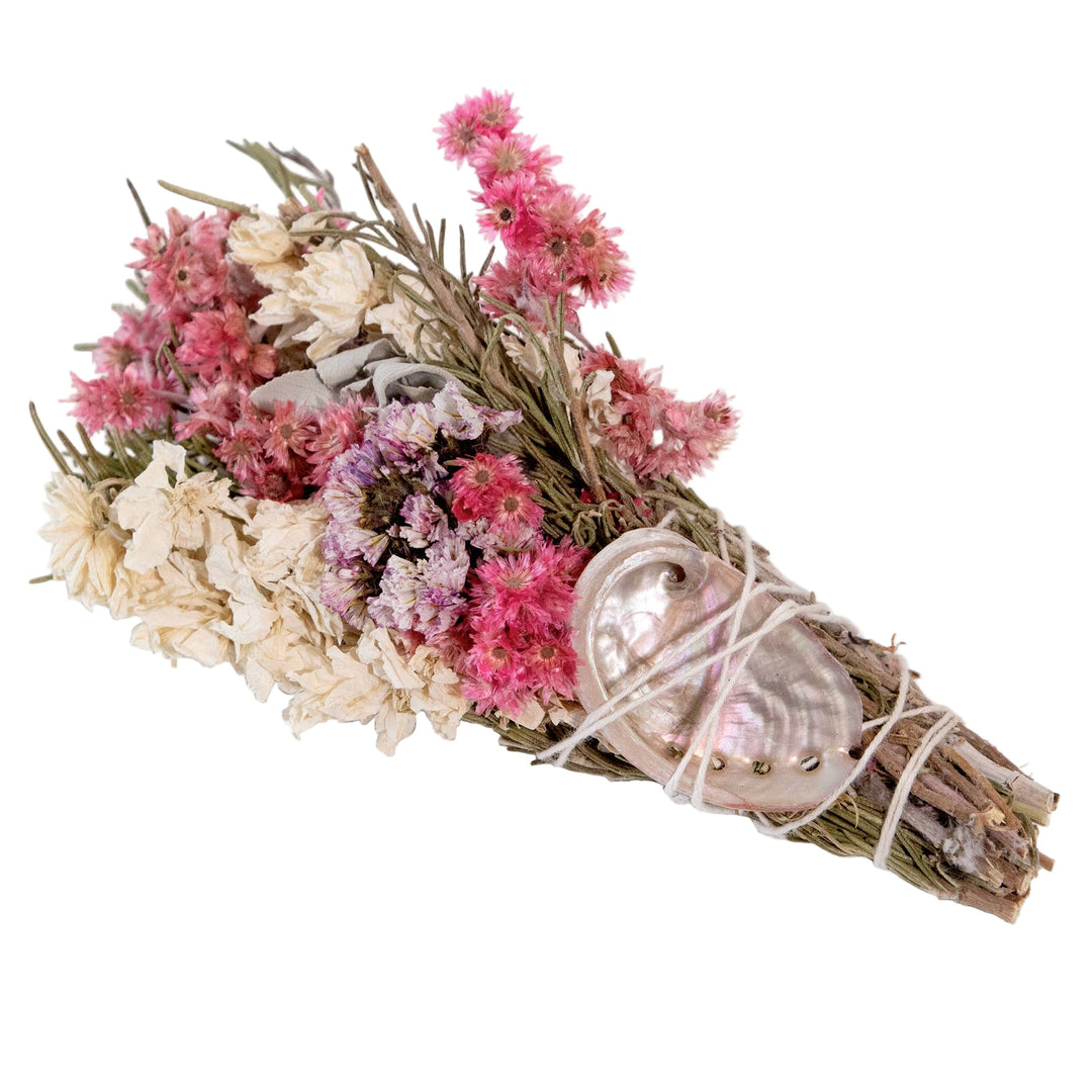 rosemary and sage bundle with white and pink dried flowers with an iridescent shell tied with a white twine