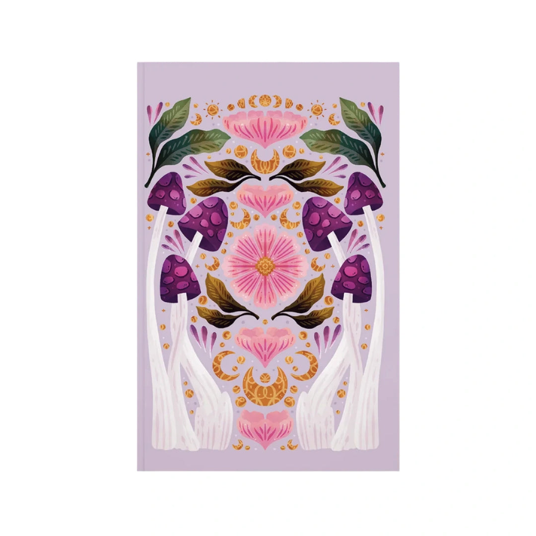 A lavender journal cover with a symmetrical design of purple mushrooms, pink flowers, green leaves, and golden decorative elements