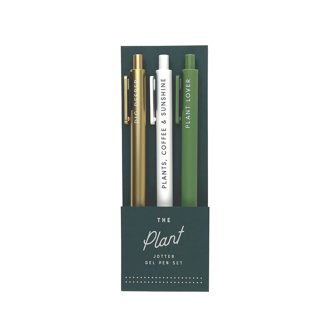 A set of three gel pens in dark green packaging labeled "The Plant Jotter Gel Pen Set." The pens come in metallic gold, crisp white, and rich green, each featuring a botanical phrase in white lettering: "Dig Deeper," "Plants, Coffee & Sunshine," and "Plant Lover."