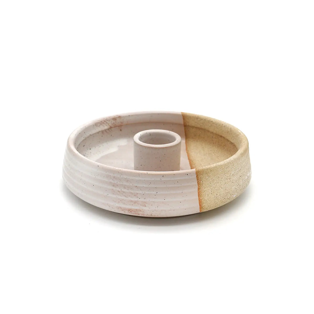 round ceramic tan and light pink palo santo burner features a hole in the center to hold a palo santo stick.