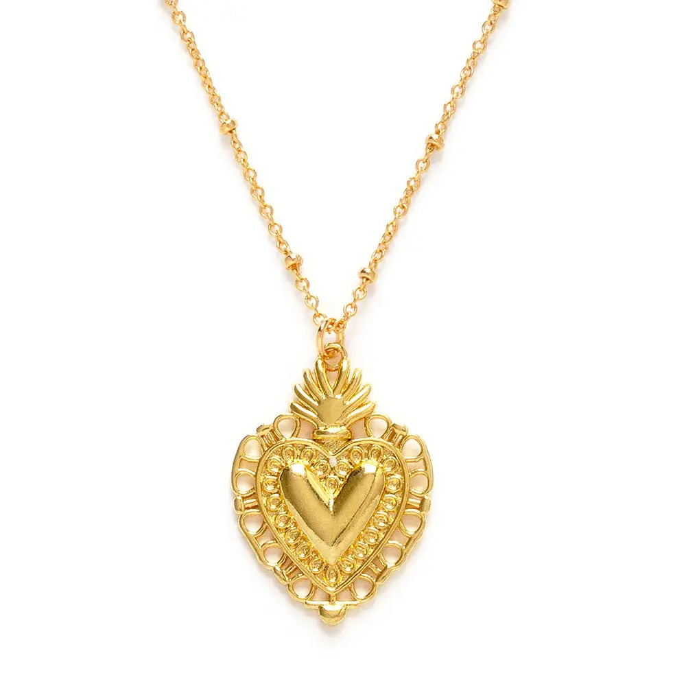 close up view of a gold sacred heard pendant on a gold chain.