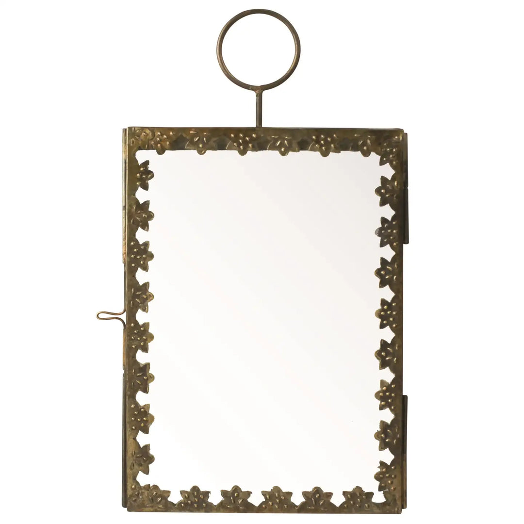 A brass hanging frame with a floral border, featuring a hinged design for inserting photos or keepsakes, topped with a round loop for hanging.