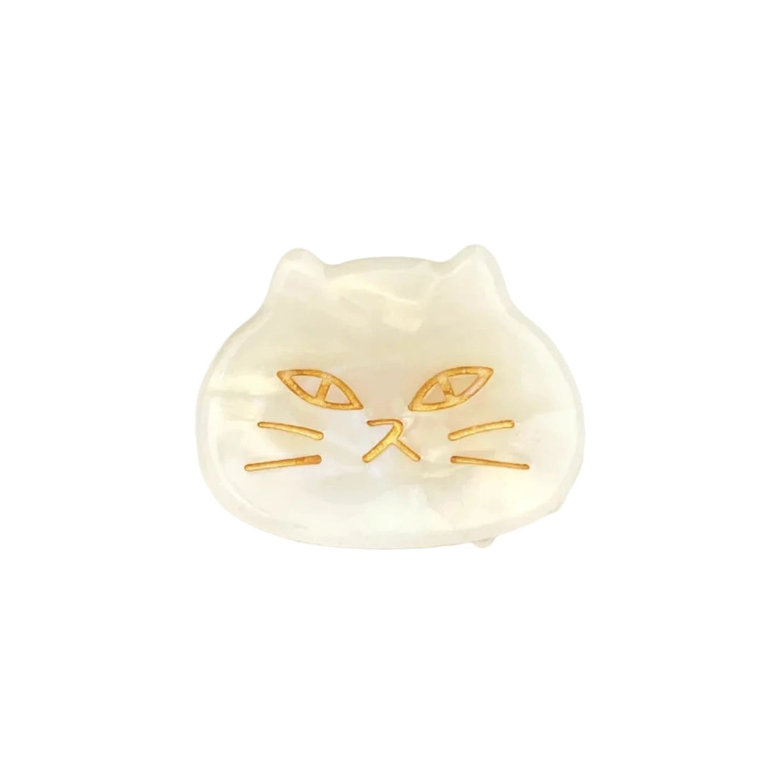 White acetate hair claw clip shaped like a cat’s head with golden etched facial details.