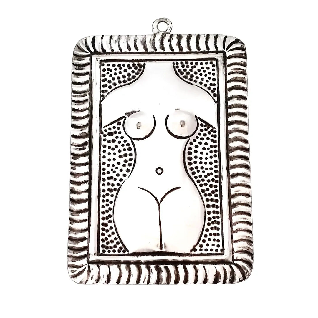 tin plaque with a hammered image of a nude female