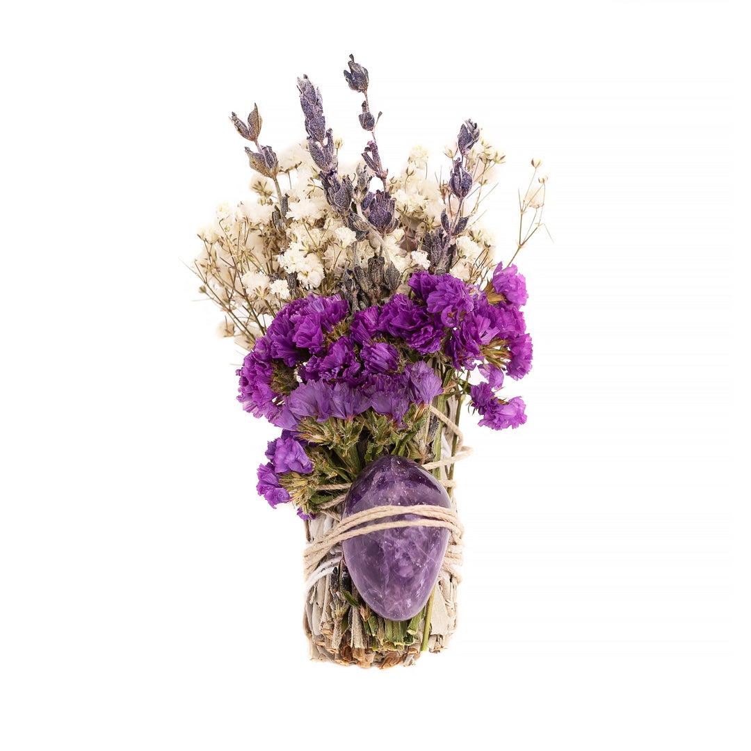 A beautifully crafted smudge bundle featuring dried purple, white, and lavender flowers tied with twine, accented with an amethyst crystal.