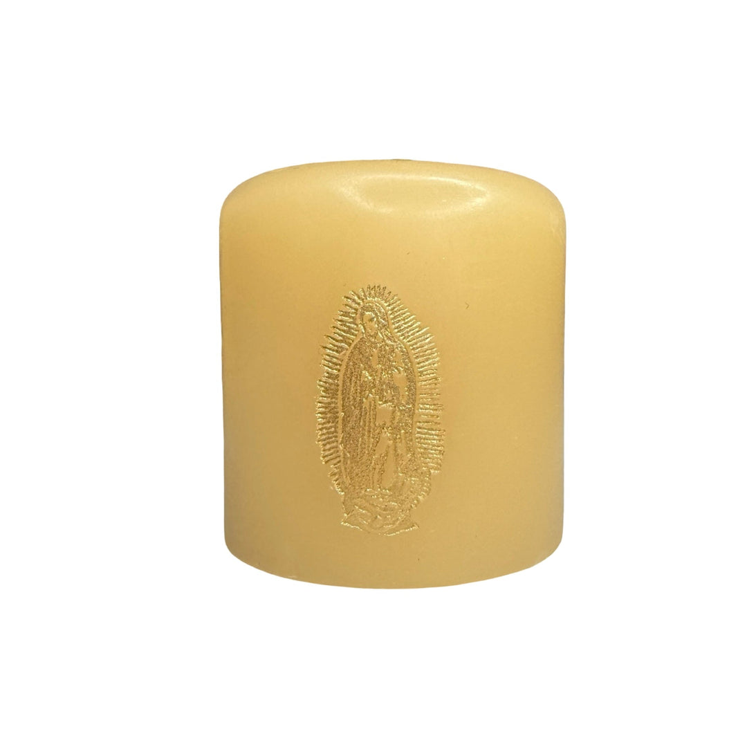 small ivory candle featuring a gold foil stamped image of Our Lady of Guadalupe on the front.