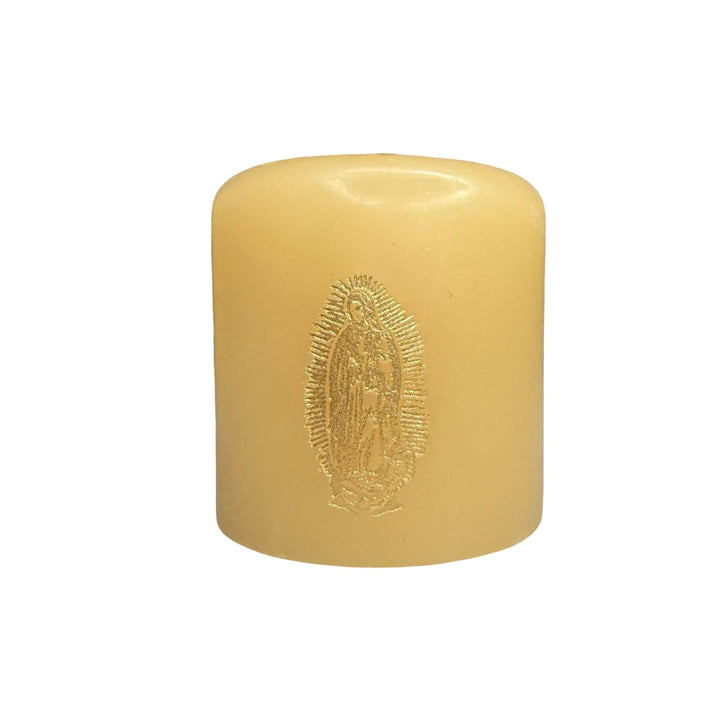 small ivory candle featuring a gold foil stamped image of Our Lady of Guadalupe on the front.
