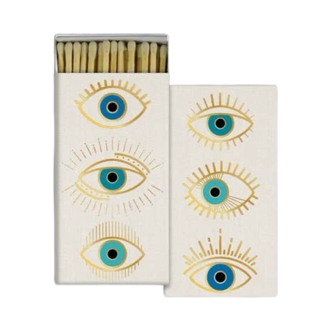 set of white boxes of matches with one box opening showing the matches and bothe featuring illustrations of blue and gold eyes.