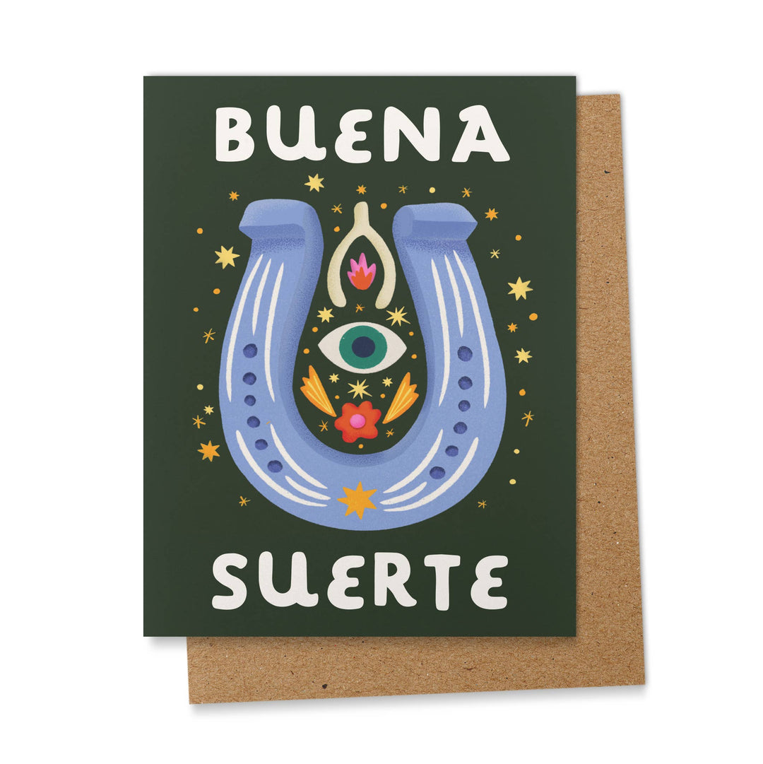 Black card with an image of a blue horseshoe, wishbone, eye and stars with the phrase Buena Suerte in white lettering.