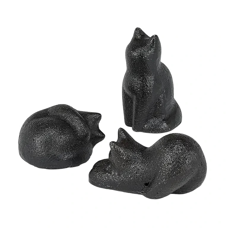 Three small cast iron black cat figurines, one curled up, one sitting upright, and one crouching.