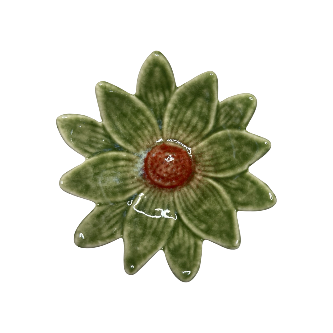 Stoneware daisy-shaped dish in dark green with a red center glaze