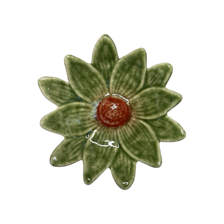 Stoneware daisy-shaped dish in dark green with a red center glaze