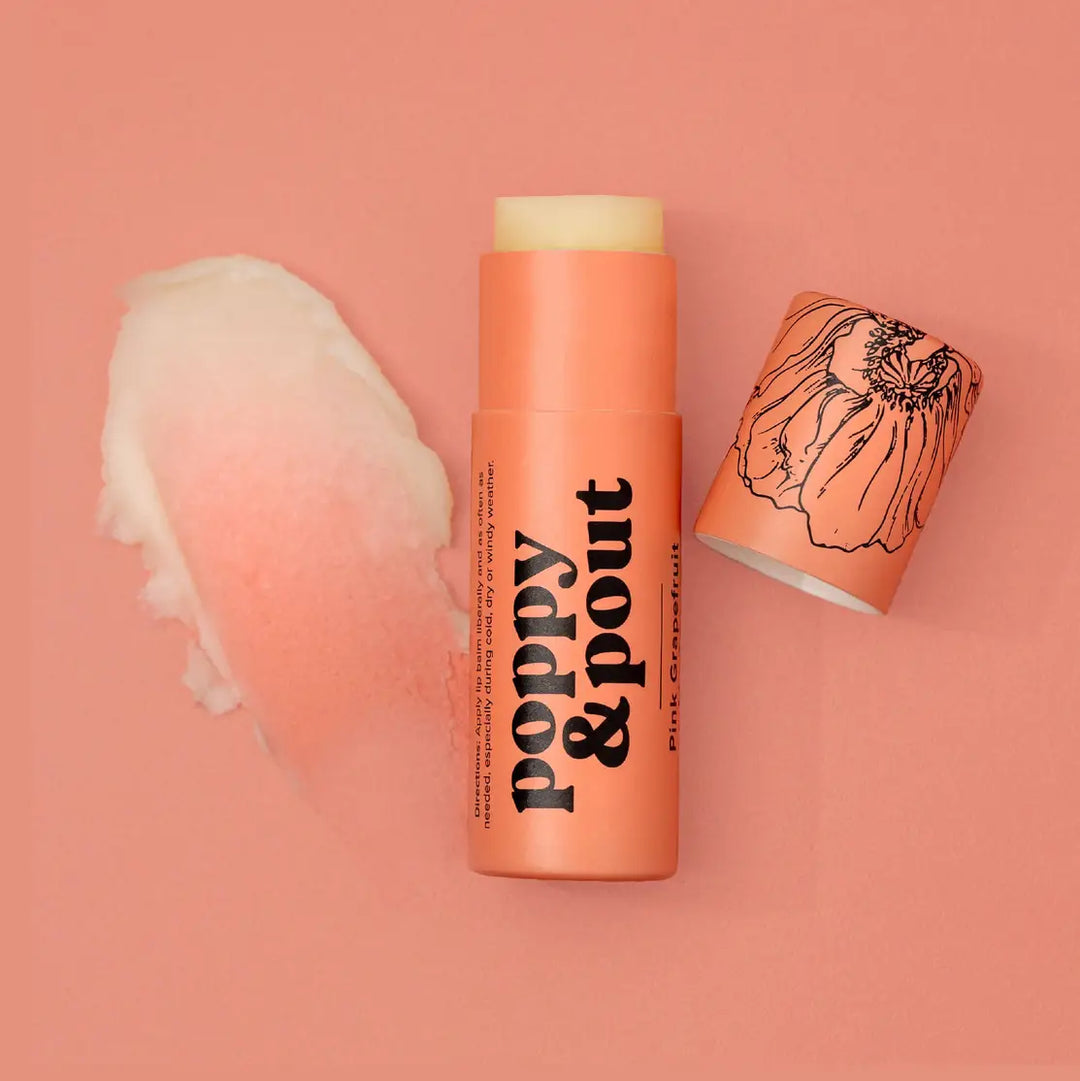 Tube of lip balm labeled “poppy & pout” with matching cap and a swatch of balm beside it.